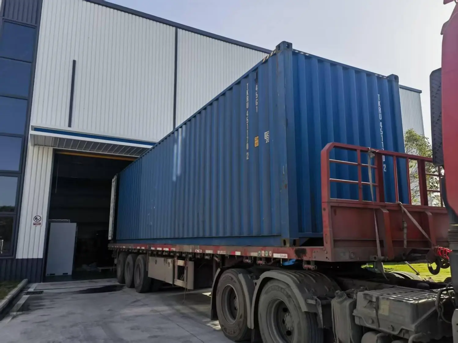 Blue shipping container loaded at an industrial facility